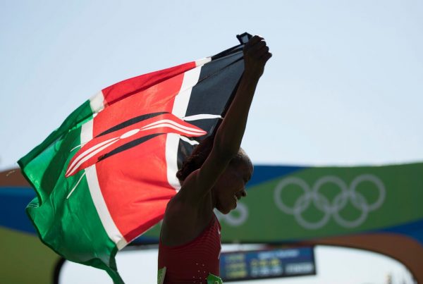a kenyan athlete holding the flag